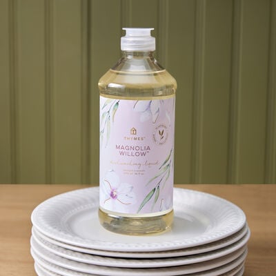 Thymes Magnolia Willow Dishwashing Liquid on a stack of plates